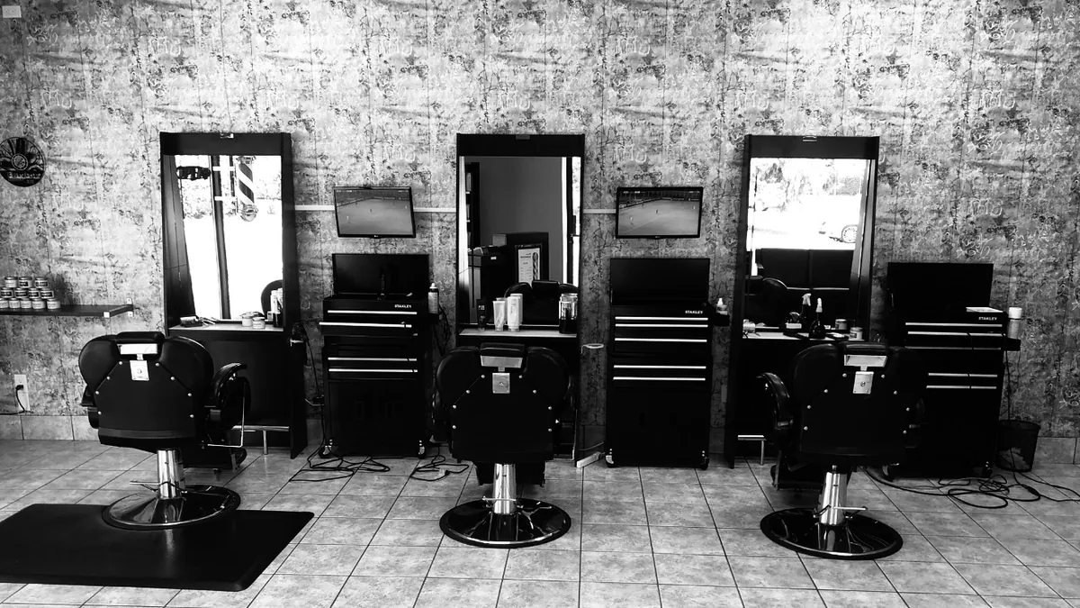 Inside Barber Stop: black barber chairs, mirrors and a wash station