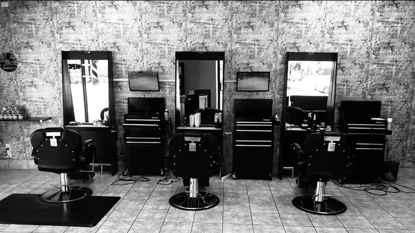 Three Barber Stop stations with black chairs and Stanley tool chests